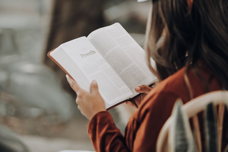 Жена чете книгата Притчи от Библията